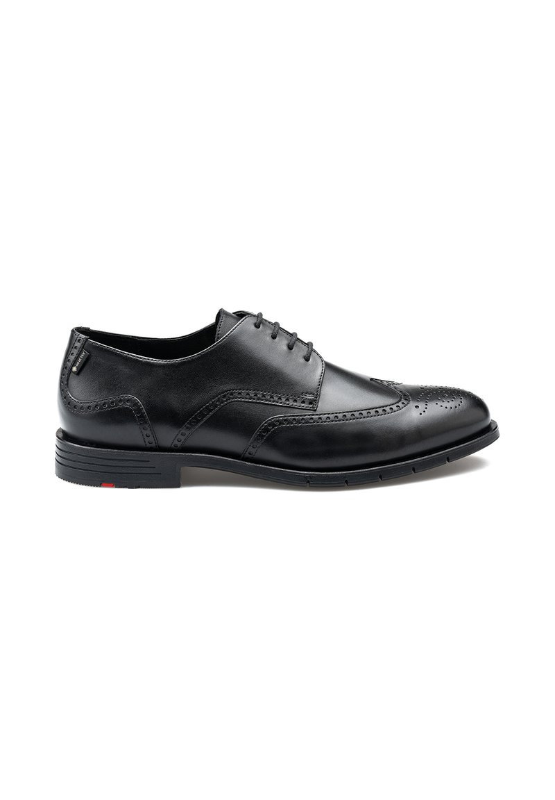 Chaussures habillées en cuir noir avec une texture lisse, design à ailes, détails brogue et semelle en caoutchouc avec une petite touche de rouge.