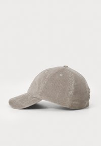 Corduroy cap in light beige, structured shape with a curved brim, six-panel design, and visible stitching. Features small vent holes.