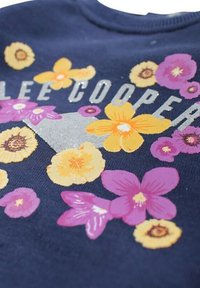 Sweatshirt bleu marine ornée d'imprimés floraux colorés en jaunes, roses et violets, avec "LEE COOPER" et des accents argentés.