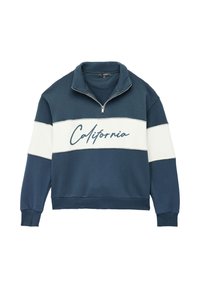 Tummansininen huppari, jossa on neljänneksen vetoketju ja korkea kaulus. Rinnan yli kulkeva valkoinen raita, jossa lukee "California" käsinkirjoitetulla fontilla. Pehmeä rakenne.