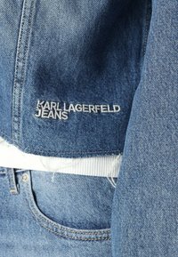 Denimjack met een lichtblauwe kleur en geborduurd 'Karl Lagerfeld Jeans' logo in het wit. Opvallende rafelige accenten aan de zoom.