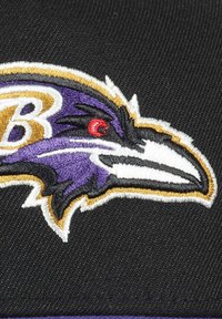 Black cap featuring an embroidered Baltimore Ravens logo. The design includes a purple raven's head with a white beak and red eye detail.
