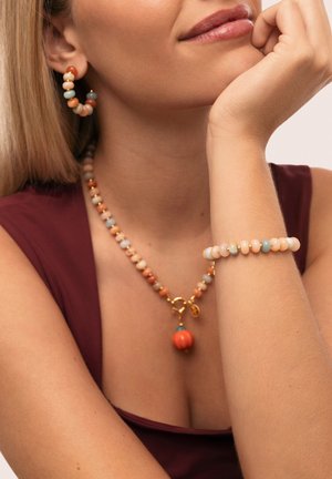 El conjunto de joyería de cuentas incluye un collar con un cierre y un colgante de oro, aretes a juego y una pulsera en tonos pastel y terrosos.