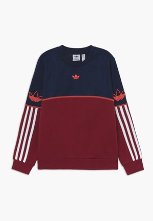Bluza Adidas z długim rękawem w kolorze granatowym na górze i bordowym na dole, z czerwonymi logo trójlistków na piersi i rękawach oraz białymi trzema paskami na ramionach.