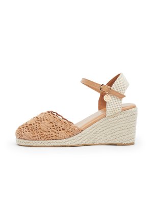Sandalo con zeppa con parte frontale beige intrecciata, cinturino alla caviglia crema con texture e fibbia, e tacco a zeppa di altezza media avvolto in corda.