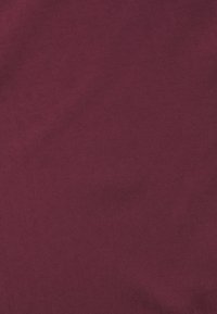 Burgundy fabric with a soft texture, featuring a subtle geometric pattern woven into the material. Ideal for various fabric applications.