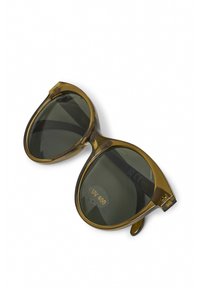 Lunettes de soleil en plastique marron avec des verres foncés surdimensionnés. Présente un label de protection UV400 sur le verre gauche et un design de monture arrondie.