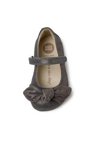 Zapato plano de cuero gris con un acabado texturizado, que presenta un lazo prominente en la punta y una correa ajustable para un ajuste seguro.