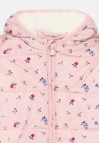 Veste doudoune rose clair avec capuche, dotée d'une doublure en polaire blanche douce et d'un imprimé floral. Fermeture éclair avec couture décorative.