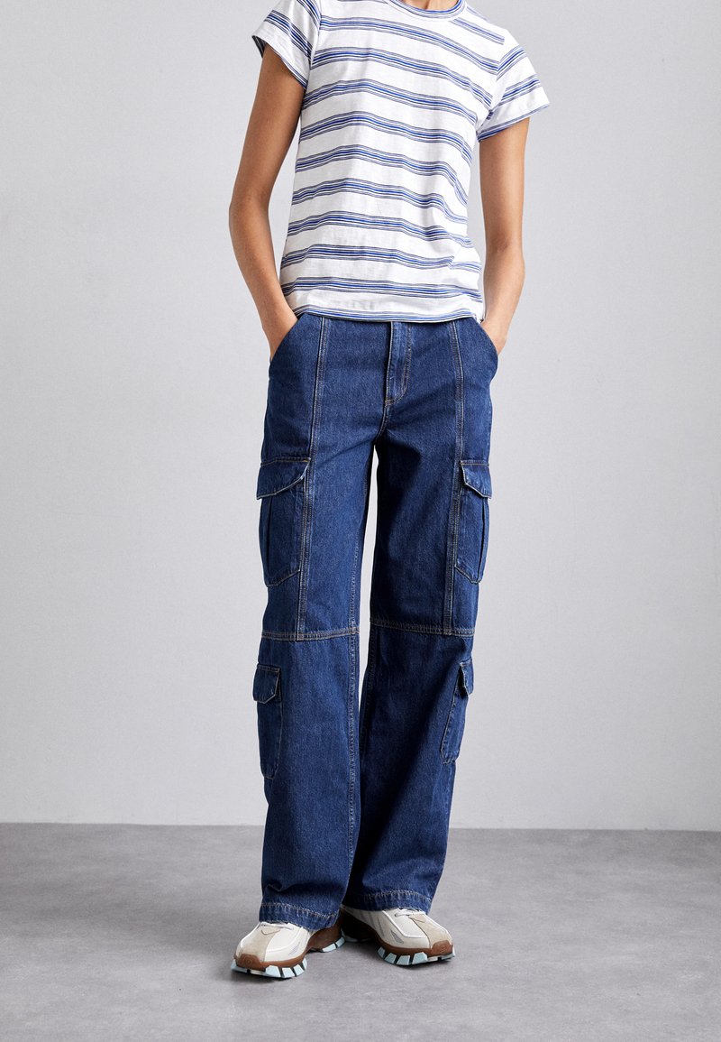 Pantaloni cargo din denim cu picioare largi și multiple buzunare, asortați cu un tricou scurt cu mâneci scurte alb și albastru cu dungi. Design confortabil.