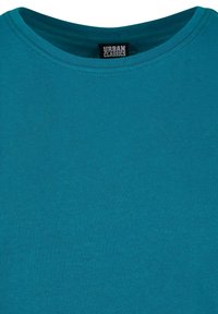 Turkizna majica s okruglim izrezom izrađena od mekog pamučnog materijala. Ima glatku teksturu s ravnim šavovima i prikazuje oznaku "URBAN CLASSICS" unutra.