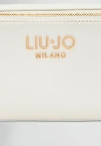 Portafoglio bianco in ecopelle con logo "LIU JO MILANO" in oro goffrato, dotato di chiusura con zip e texture liscia.