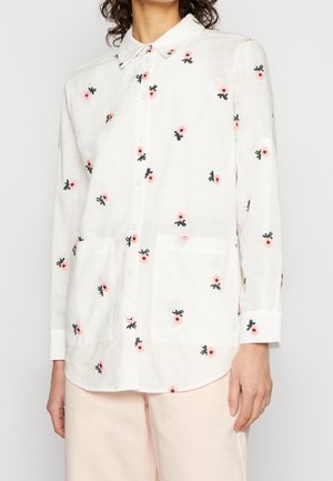 Langærmet hvid skjorte med lyserød og grøn blomsterbroderi, knappet front, krave og to forlommer. Letvægts, struktureret stof.