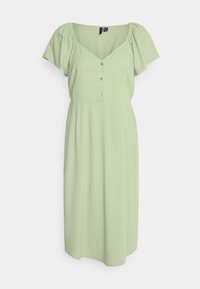 Vaaleanvihreä mekko lyhyillä puffihihnoilla, V-pääntiellä ja nappiyksityiskohdilla edessä. Sileä kangas, polvipituinen, rento malli.