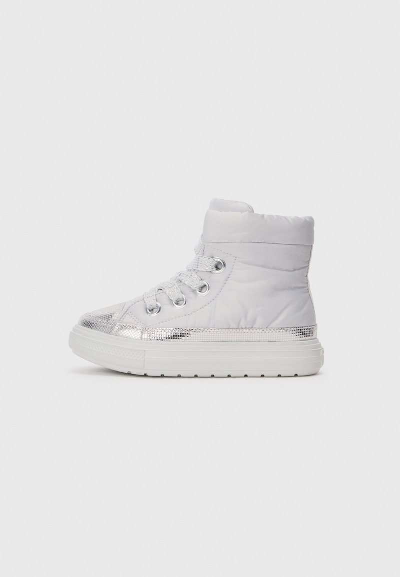 Zapatilla alta blanca con un diseño acolchado, acentos metálicos en plata, cordones en la parte delantera y una suela texturizada. Presenta un tobillo acolchado para mayor soporte.