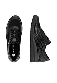 Chaussures de sport noires avec un mélange de matériaux lisses et texturés, dotées d'un laçage à l'avant et d'une fermeture éclair sur le côté pour un enfilage facile.