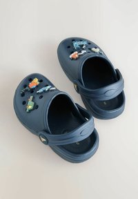 Sinised plastist sabad mitmesuguste värviliste ja mänguliste kaunistustega peal. Omavad ventilatsiooniauke ja tagaosa rihma toe tagamiseks.