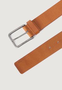 Curea din piele maro deschis cu cataramă din metal argintiu, având o textură netedă și cinci găuri ajustabile pentru dimensiune, branduită cu Calvin Klein.