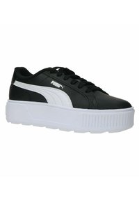 Sneaker sintetiche nere con una striscia laterale e logo bianchi, caratterizzate da una suola bianca spessa e dettagli texture sulla parte frontale.