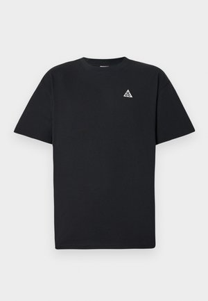 T-shirt preta de manga curta, feita de algodão, apresentando um pequeno logotipo triangular branco na área esquerda do peito, com um design padrão de gola redonda.