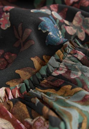 Schwarzer Stoff mit floralen Motiven in lebendigen Farben und Texturen. Verfügt über gekräuselte Kanten und komplexe Muster von Blättern und Blumen in unterschiedlichen Farbtönen.
