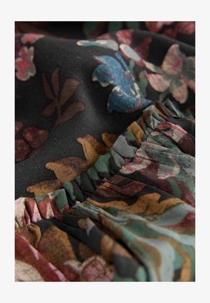 Lilleline must kangas, millel on elavad värvid ja tekstuurid. Sellel on volangilised servad ja keerukad mustrid lehtedest ja lilledega erinevates toonides.