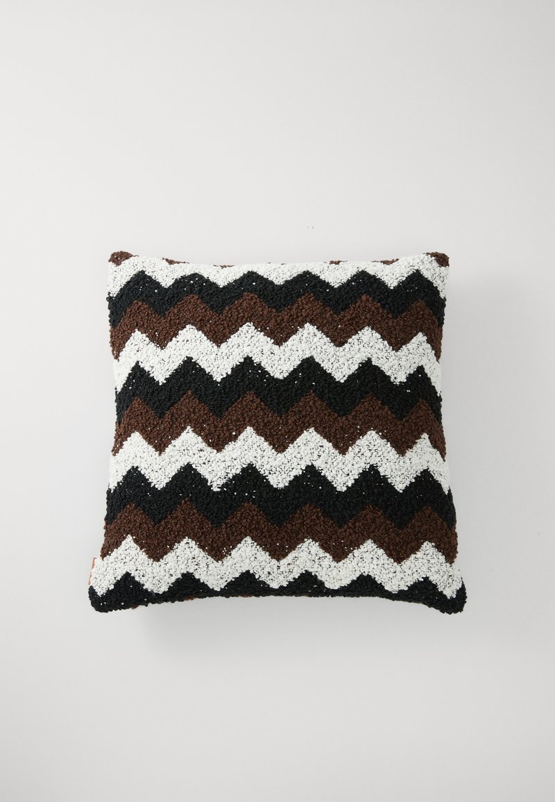 Teksturerte firkantede puter med et sikksakkmønster i brunt, hvitt og svart, med en taktil overflate og distinkt fargekontrast.