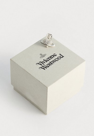 Sølv stjernesmykke med en teksturert Saturn-design, plassert på en lys beige Vivienne Westwood-merket boks.