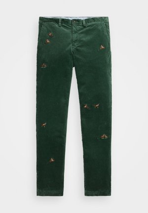 Pantalones de pana verdes con diseño de pierna recta, que presentan pájaros bordados en diversos colores y una cinturilla estándar con un botón en la parte frontal.