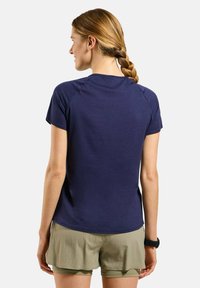 Navyblauwe T-shirt met korte mouwen, naadloos schouderontwerp en een ronde hals. Gepaarde met lichte khaki shorts.