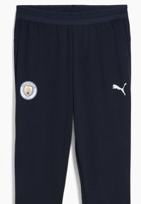 Marineblaue Sporthosen verfügen über das Logo von Manchester City und ein weißes Puma-Logo an der Seite, entworfen für Sportbekleidung und Komfort.