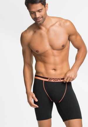 Boxer neri con una cintura arancione "SPORT". Presentano una vestibilità aderente, un tessuto liscio e una lunghezza a metà coscia. Nessun ulteriore motivo o dettaglio.