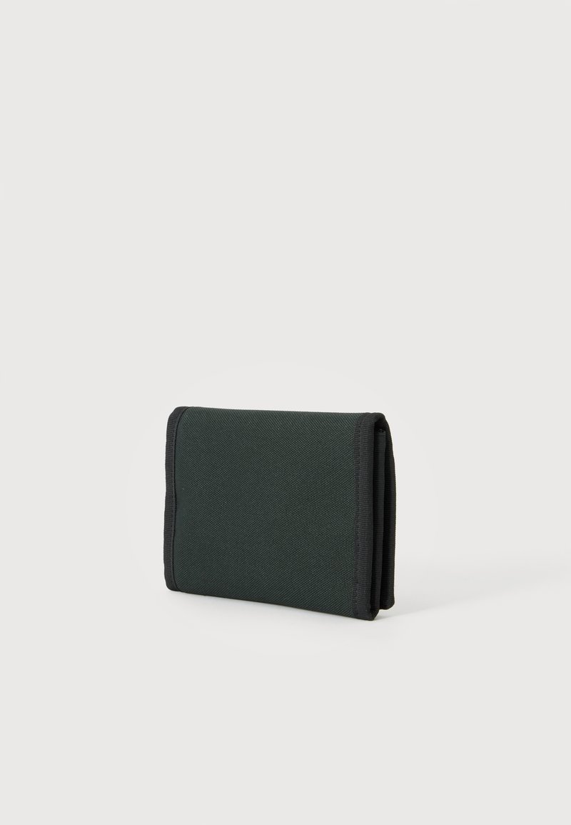 Cartera de tela negra plegada con bordes cosidos sobre un fondo gris claro liso.