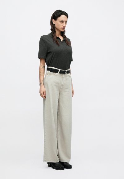 Σκούρο γκρι πόλο μπλουζάκι, ψηλόμεσα ανοιχτό γκρι φαρδιά τζιν παντελόνια, μαύρη ζώνη, μαύρα χοντρά παπούτσια, μινιμαλιστικός σχεδιασμός, χωρίς σχέδια ή διακοσμητικά στοιχεία.