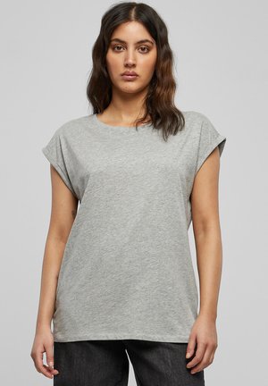 Grijs T-shirt met korte mouwen, opgerolde mouwen, ronde halslijn en een zachte, gladde textuur. Losse pasvorm, gecombineerd met een donkere broek.