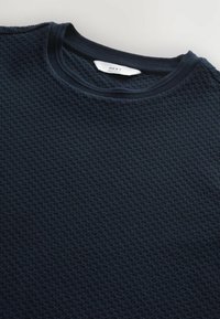 Pull en maille bleu marine avec un motif en grille, col rond et poignets et col en côte contrastés. L'étiquette indique "NEXT Regular Fit."