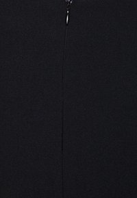 Tissu noir avec une fermeture éclair verticale centrée, tirette visible près du haut, texture lisse et légèrement mate.