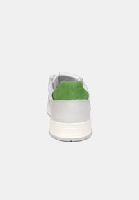 Sneaker bianco con accenti in camoscio grigio chiaro e un tallone posteriore verde brillante. Presenta una texture liscia e un design della punta arrotondata.