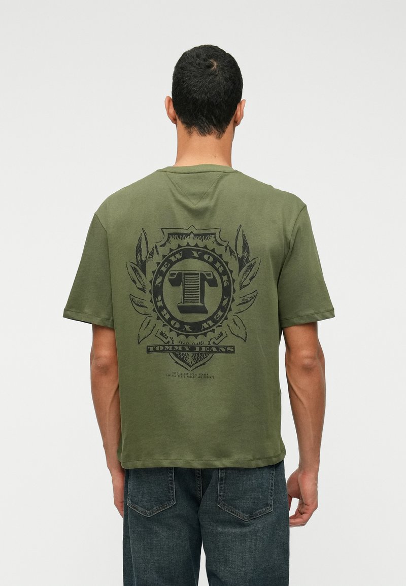 Õlivaheline t-särk, mis on valmistatud puuvillast, musta graafilise logoga, millel on laurolilled tagaküljel. Lühikesed varrukad ja lõdvestatud istuvus.