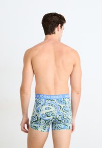 Ανδρικά μποξεράκια με ελαστική μέση σε μπλε απόχρωση με το κείμενο "BJÖRN BORG", διακοσμημένα με πολύχρωμα σχέδια και λουλούδια.