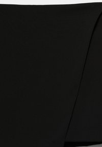 Svart tyg med en slät, något texturerad yta; har subtila draperingar som skapar ett lagerutseende.