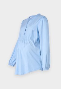 Svetle modrá těhotenská blůza s dlouhými nadýchanými rukávy, výstřihem s notchem a nařasením v přední části. Měkká tkanina s volným střihem.