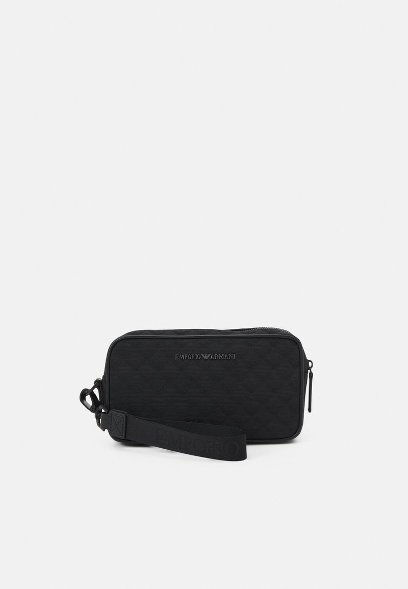 Pochette nera in tessuto trapuntato con zip, caratterizzata dal logo "Emporio Armani" in rilievo e una tracolla removibile per maggiore versatilità.