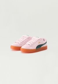 Baskets en suède rose clair avec des accents verts, dotées d'une semelle en gomme texturée et de lacets plats. Marquage doré sur le côté.