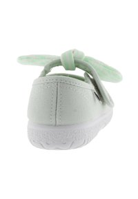 Zapatilla de lona verde claro con un upper texturizado, suela de goma blanca y un lazo atado en la parte trasera. Diseño simple y plano sin acentos adicionales.