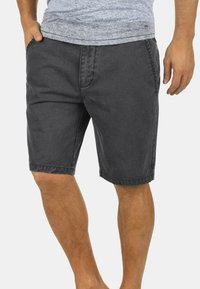 Shorts en coton gris avec une coupe décontractée, deux poches latérales, un ourlet cousu et une texture douce légèrement délavée.