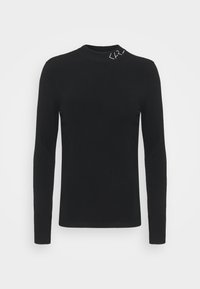 Pull cintré à col roulé noir à manches longues avec un petit détail brodé blanc près du col.