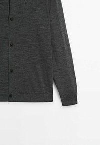 Cardigan gris foncé à manches longues boutonné, en tissu tricoté fin, présenté de la taille au poignet sur fond blanc.