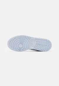 Outsole Nike tenisky z ľahkého modrého gumového materiálu, s kruhovým vzorom, textúrovanými úchopmi a centrálnym detailom loga v tvare kruhu.