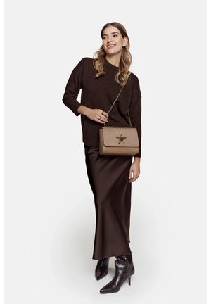Maglione marrone a maglia, gonna di satin marrone e stivaletti neri con punta affusolata. Borsa beige con tracolla a catena e dettaglio a stella.